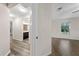 Bright hallway leading to a bathroom with dark wood cabinets and a bedroom with wood-look flooring at 3720 Edsel Ave, St Cloud, FL 34772