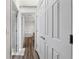 Hallway view with multiple doors, wood-look flooring and a glimpse of a freestanding tub at 3720 Edsel Ave, St Cloud, FL 34772