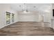 Spacious living room featuring wood-look flooring, ceiling fan, and double doors with blinds at 3720 Edsel Ave, St Cloud, FL 34772