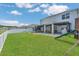 Spacious backyard featuring a playset, covered patio, trampoline, and lake views at 374 Pine Tree Bridge Trl, St Cloud, FL 34772