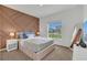 Bedroom features an accent wall and a plush bed with storage underneath and a view to the outside at 374 Pine Tree Bridge Trl, St Cloud, FL 34772