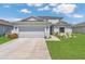 Charming two-story home with a two-car garage, well-maintained lawn, and landscaping under a bright sky at 374 Pine Tree Bridge Trl, St Cloud, FL 34772