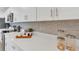 Close-up of a modern kitchen featuring sleek countertops, stainless steel appliances, and stylish backsplash at 374 Pine Tree Bridge Trl, St Cloud, FL 34772