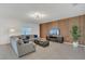 Spacious living room with comfortable gray sectional, wood accent wall, and tiled floors at 374 Pine Tree Bridge Trl, St Cloud, FL 34772