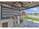 This outdoor kitchen features a grill, a beverage fridge, and a sink under a covered patio at 374 Pine Tree Bridge Trl, St Cloud, FL 34772