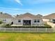 Cozy backyard featuring a patio, enclosed patio, white fence, and lush green lawn at 3844 Cabo Rojo Dr, St Cloud, FL 34772