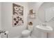 Stylish powder room with pedestal sink, decorative art, and modern fixtures at 3844 Cabo Rojo Dr, St Cloud, FL 34772