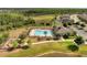 Aerial view of community pool, playground, and green space in a neighborhood with landscaping and trees at 3844 Cabo Rojo Dr, St Cloud, FL 34772