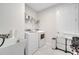Functional laundry room with white washer, dryer, utility sink and storage shelves at 3844 Cabo Rojo Dr, St Cloud, FL 34772