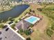 Aerial view of a community pool, clubhouse, parking and adjacent lake at 3844 Cabo Rojo Dr, St Cloud, FL 34772