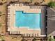 Aerial view of community pool with brick surround, lounge chairs, and lush landscaping at 3844 Cabo Rojo Dr, St Cloud, FL 34772