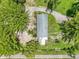 Aerial view of a small home surrounded by mature trees and a gravel driveway at 429 Diamond Acres Rd, Davenport, FL 33837