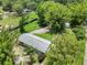 Aerial view of a property showcasing the home, outbuildings, expansive yard, and surrounding mature landscaping at 429 Diamond Acres Rd, Davenport, FL 33837