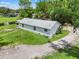 Aerial view showcasing the home, gravel driveway, and lush mature landscaping at 429 Diamond Acres Rd, Davenport, FL 33837