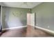 Bedroom with wood floors, ceiling fan, and large roman numeral wall clock at 429 Diamond Acres Rd, Davenport, FL 33837