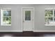 Bright entryway featuring dark hardwood floors, white door and trim and two windows at 429 Diamond Acres Rd, Davenport, FL 33837