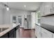 Bright kitchen features stainless steel refrigerator, white cabinets, granite countertops and wood floors at 429 Diamond Acres Rd, Davenport, FL 33837