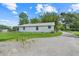 Rear exterior of a single-story home with an expansive gravel driveway at 429 Diamond Acres Rd, Davenport, FL 33837