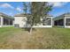 A view of the home's backyard with a tree and a screened in lanai at 4324 Desert Rose, Kissimmee, FL 34746