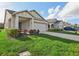 A view of the home's exterior, featuring an attached two-car garage, front yard, and tidy landscaping at 4324 Desert Rose, Kissimmee, FL 34746