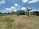 A serene backyard featuring a covered patio, palm trees, privacy fence, and outdoor living, ideal for relaxation at 4804 Marcos Cir, Kissimmee, FL 34758