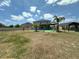 A serene backyard featuring a covered patio, palm trees, privacy fence, and outdoor living, ideal for relaxation at 4804 Marcos Cir, Kissimmee, FL 34758