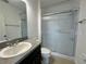 A bathroom with a single sink vanity and a shower with sliding glass doors at 4804 Marcos Cir, Kissimmee, FL 34758