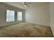 Large bedroom featuring carpet, a ceiling fan, and two windows with sheer curtains at 4804 Marcos Cir, Kissimmee, FL 34758