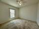 Cozy bedroom with neutral carpet, ceiling fan, and a bright window offering natural light at 4804 Marcos Cir, Kissimmee, FL 34758