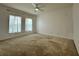 Large bedroom featuring carpet, a ceiling fan, and two windows with sheer curtains at 4804 Marcos Cir, Kissimmee, FL 34758