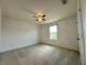 Cozy bedroom featuring a ceiling fan, neutral carpeting, and a window with backyard views at 4804 Marcos Cir, Kissimmee, FL 34758