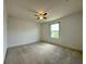 Bright bedroom features a lighted ceiling fan, neutral carpeting and a sunny window at 4804 Marcos Cir, Kissimmee, FL 34758