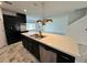 Open kitchen featuring a large island with modern light fixtures and black cabinets at 4804 Marcos Cir, Kissimmee, FL 34758