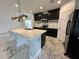 Stylish kitchen featuring an island with decorative stonework and black cabinets at 4804 Marcos Cir, Kissimmee, FL 34758