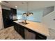 Modern kitchen featuring dark cabinets, stainless steel appliances, and a large island with a double sink at 4804 Marcos Cir, Kissimmee, FL 34758