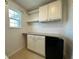 Laundry room with storage cabinets, countertop, and a mini-refrigerator for added convenience at 4804 Marcos Cir, Kissimmee, FL 34758