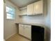 Bright laundry room featuring white cabinets, shelving, mini-fridge and a window providing natural light at 4804 Marcos Cir, Kissimmee, FL 34758