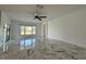 Bright living room featuring a ceiling fan, white walls, large windows, and marble tile flooring at 4804 Marcos Cir, Kissimmee, FL 34758