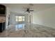 Bright living room featuring a ceiling fan, white walls, large windows, and marble tile flooring at 4804 Marcos Cir, Kissimmee, FL 34758
