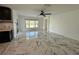 Bright living room featuring a ceiling fan, white walls, large windows, and marble tile flooring at 4804 Marcos Cir, Kissimmee, FL 34758