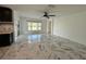 Bright living room featuring a ceiling fan, white walls, large windows, and marble tile flooring at 4804 Marcos Cir, Kissimmee, FL 34758