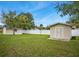 Large backyard featuring green grass, two sheds, and a white fence at 483 Stillwater Dr, Oviedo, FL 32765