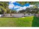 Expansive backyard with a well-maintained lawn, mature trees, and a patio area at 502 Engel Dr, Orlando, FL 32807