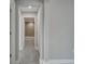 Hallway leading to a brightly lit bathroom with tile flooring, a toilet, and a vanity at 502 Viceroy Ct, Kissimmee, FL 34758