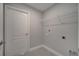 Bright laundry room with a white door, wire shelving, and neutral wall color at 502 Viceroy Ct, Kissimmee, FL 34758