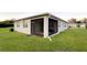 Exterior view of the screened-in lanai with a dark screen and views of the backyard at 5306 Meadow Song Dr, Okahumpka, FL 34762