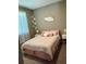 Comfortable bedroom featuring a geometrically patterned duvet, soft pillows, and natural light from the window at 5306 Meadow Song Dr, Okahumpka, FL 34762