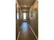 Long hallway with wood flooring, neutral walls, white trim and recessed lighting at 5306 Meadow Song Dr, Okahumpka, FL 34762