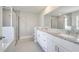 Beautifully designed bathroom featuring double sinks, white cabinets, and a glass-enclosed shower at 563 Viceroy Ct, Kissimmee, FL 34758