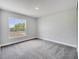 Bright, carpeted bedroom featuring a large window for natural light and neutral walls at 563 Viceroy Ct, Kissimmee, FL 34758